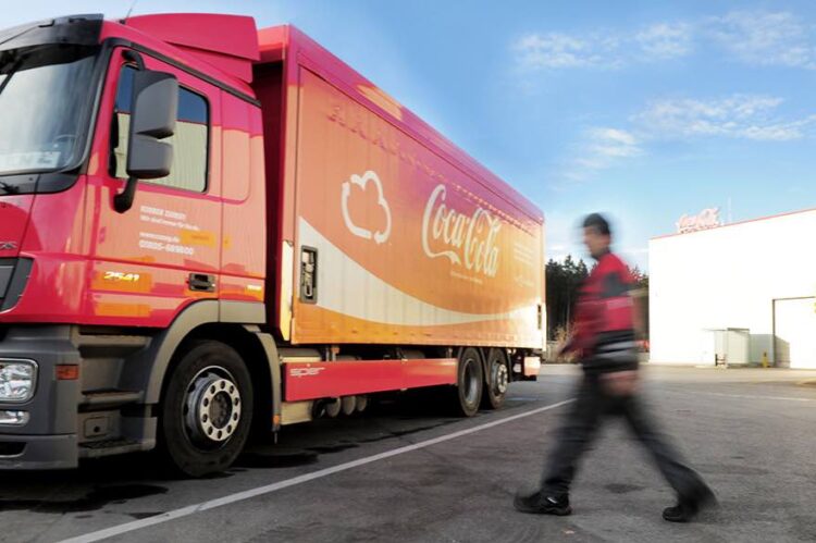 Lkw-Fahrer läuft zu Coca-Cola-Lkw