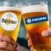 Gläser mit Logos von Warsteiner und Karlsberg stoßen an