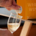 Hand füllt Wein aus Bag-in-Box in ein Glas