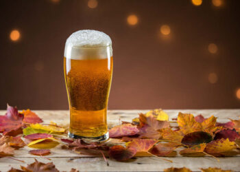 Bierglas auf Tisch mit Herbstlaub