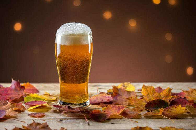 Bierglas auf Tisch mit Herbstlaub