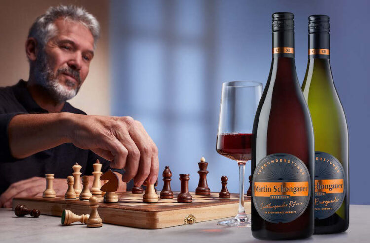 Mann beim Schachspielen mit zwei Flaschen "Burgunderstunde"