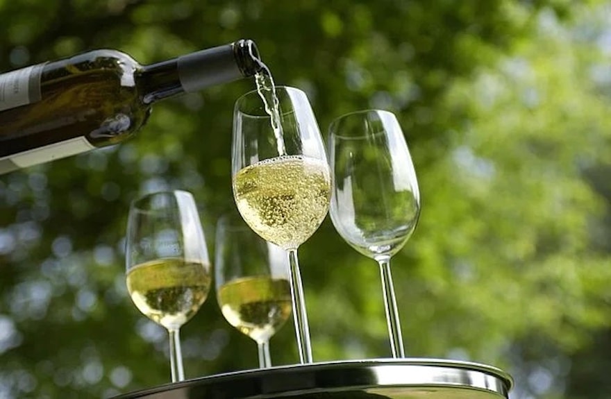 Weißwein wird in Gläser eingeschenkt