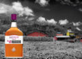 Fotomontage: Neisson-Flasche steht vor Destillerie in Zuckerrohrfeld.