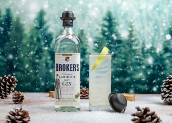 Broker's-Gin-Flasche und Longdrinkglas vor Winterlandschaft