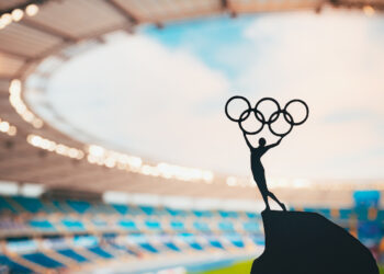 Statue mit Olympischen Ringen in einem Stadion