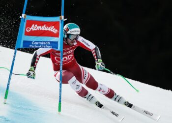 Skiprofi fährt an Torflagge mit Almdudler-Logo vorbei
