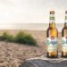 Zwei Lübzer-Bierflaschen in Dünenlandschaft am Meer