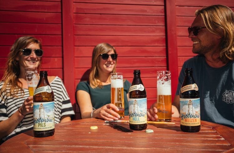 Zwei Frauen und ein Mann trinken Biere der neuen Range.