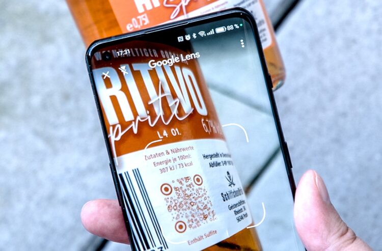 Smartphone, das einen QR-Code auf einer Flasche scannt