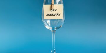 Leeres Weinglas mit angeklammertem Zettel "Dry January"