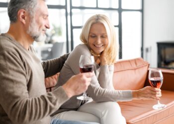 Mann und Frau beim Weintrinken auf dem Sofa