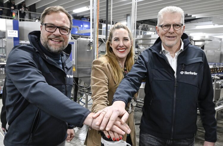 Catharina Cramer gibt gemeinsam mit dem Technikgeschäftsführer Jens Hoffmann (links) und dem Herforder Standortverantwortlichen Frank Rottmann den Startschuss für die neue Abfüllanlage der Herforder Brauerei. (Foto: Fotodesign Freitag)