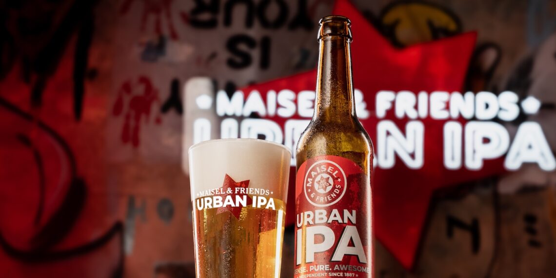 Eine Flasche Ein Bier "für Tag und Nacht": das neue Maisel & Friends Urban IPA und ein passendes Glas vor einer urbanen Leuchtreklame der Marke