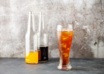 Foto einer Cola- und Orangenlimo-Flasche sowie ein fertig gemischtes Spezi
