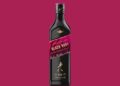 Eine Flasche Johnnie Walker Black Ruby vor weinrotem Hintergrund