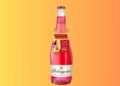 Eine Flasche Rotkäppchen Fruchtsecco Granatapfel mit einem Neckhanger, der auf die Sommeraktion hinweist