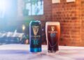 Eine Dose und ein Glas Guinness 0.0 vor einer Backsteinwand
