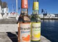 Je eine Flasche Strandgut Bitterorange und Limoncello auf einem Holzsteg am Hafen