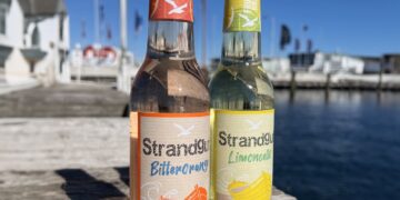 Je eine Flasche Strandgut Bitterorange und Limoncello auf einem Holzsteg am Hafen