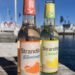 Je eine Flasche Strandgut Bitterorange und Limoncello auf einem Holzsteg am Hafen
