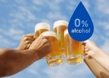 vier Hände stoßen mit Biergläsern an