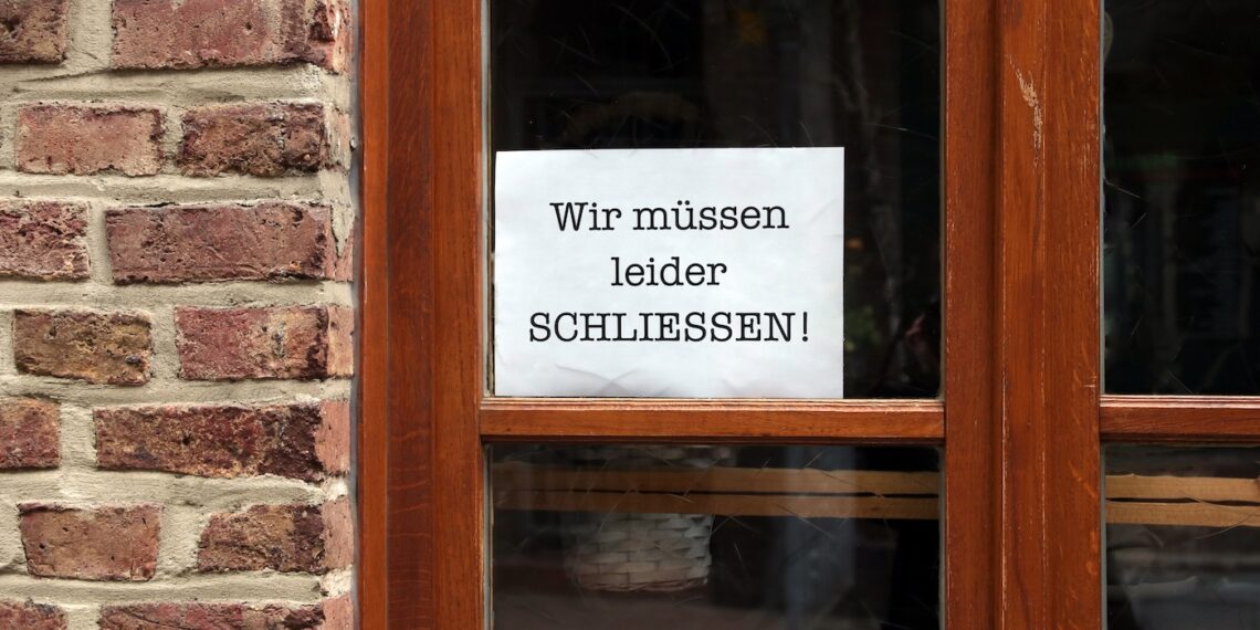 Restauranttür mit einem Schild "Wir müssen leider schließen"